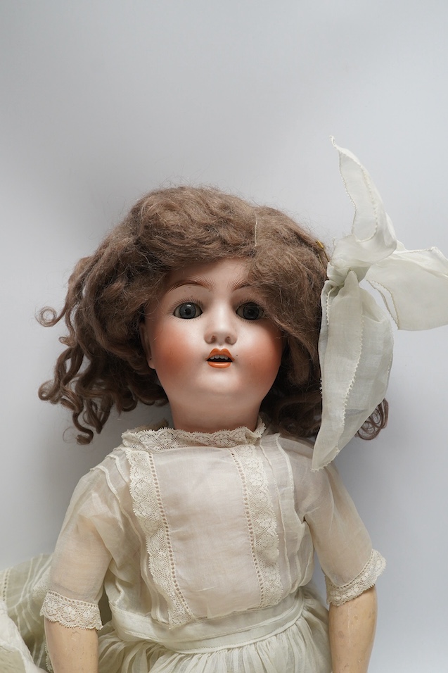 An Alt. Beck & Gottschalk bisque doll and three baby dresses, 61cm high. Condition - no visible hairline cracks to head or serious damage to body, dresses and dolls dress in good order, may need washing